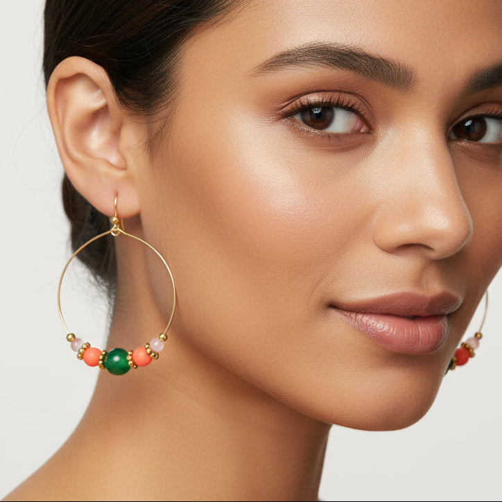 Gold hoop earrings with colorful beads on a white background