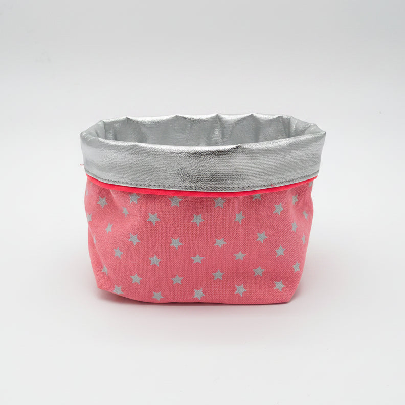 Fabric basket with pink exterior and silver interior on a white background