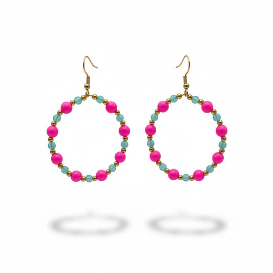 A pair of handmade hoop earrings with bright pink and turquoise beads against a neutral gray background.
