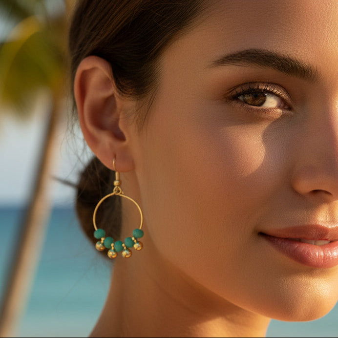 Gold hoop earrings with turquoise beads on a white background