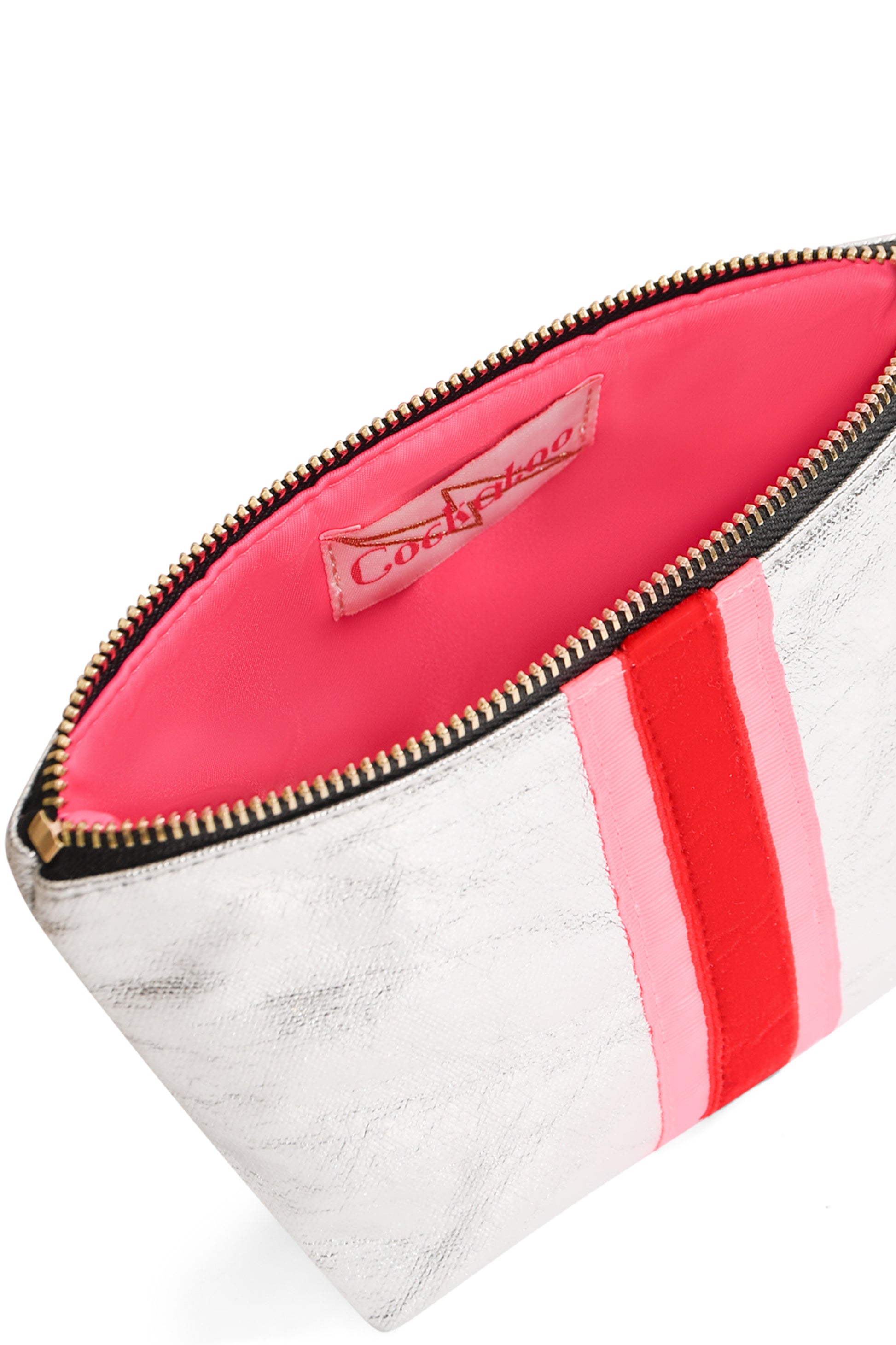 Close up of silver clutch bag showing red velvet stripe and hot pink water-resistant lining with gold zip